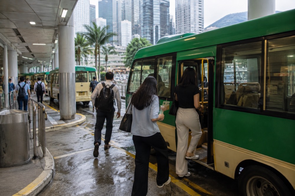 Green Hong Kong minibus at a transport interchange with passengers boarding
