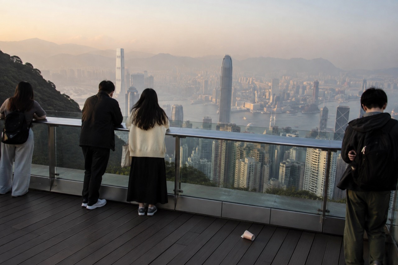 The Peak Tower viewing deck and Hong Kong skyline seen from the hillside above the harbour
