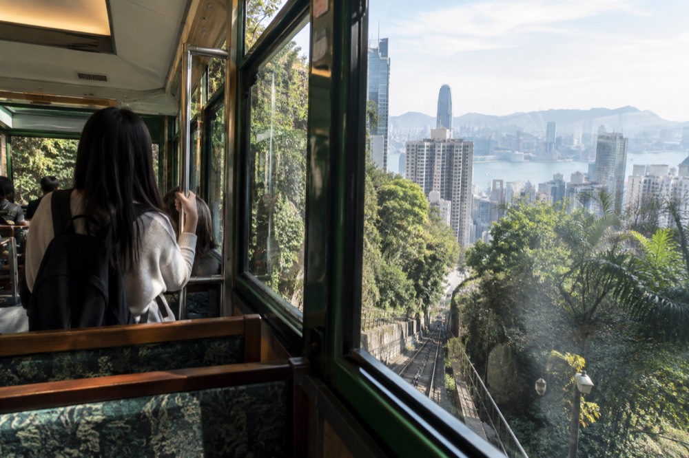 Interior of a Peak Tram car with panoramic windows and rows of seats on the uphill climb