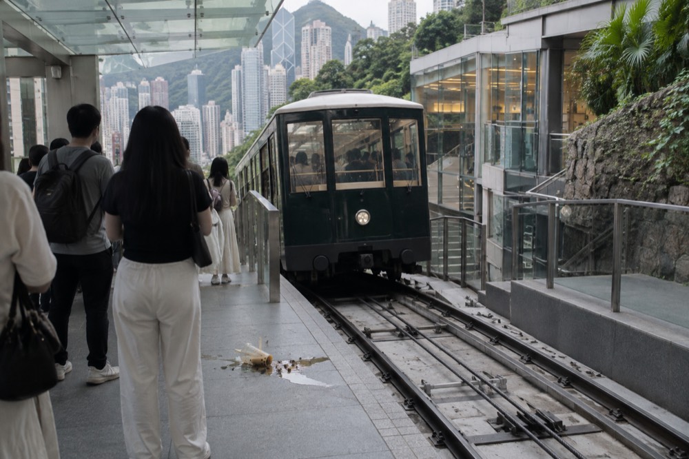 Peak Tram car arriving at the Garden Road lower terminus platform in daylight