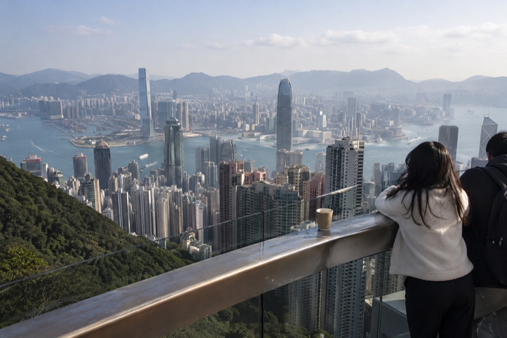 View over Hong Kong skyscrapers and Victoria Harbour from a high observation deck on a clear afternoon