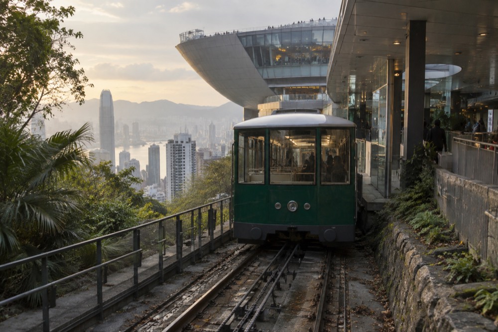 Green Peak Tram car arriving at the upper terminus at Victoria Gap with the wok-shaped Peak Tower behind