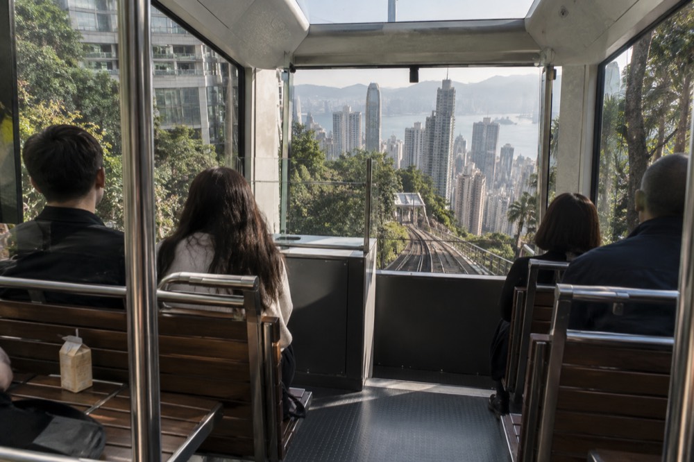Interior of a modern Peak Tram car with panoramic windows and a waveform floor for standing passengers