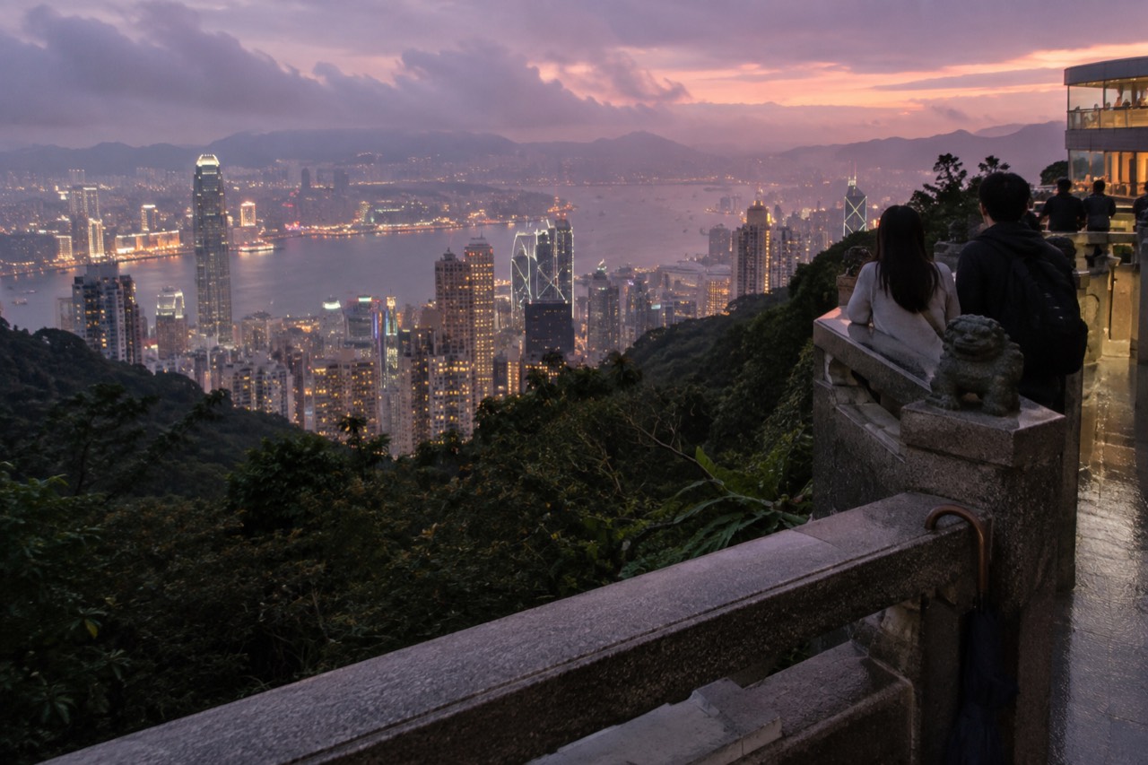 Hong Kong skyline and harbour seen from the hillside above the city at dusk