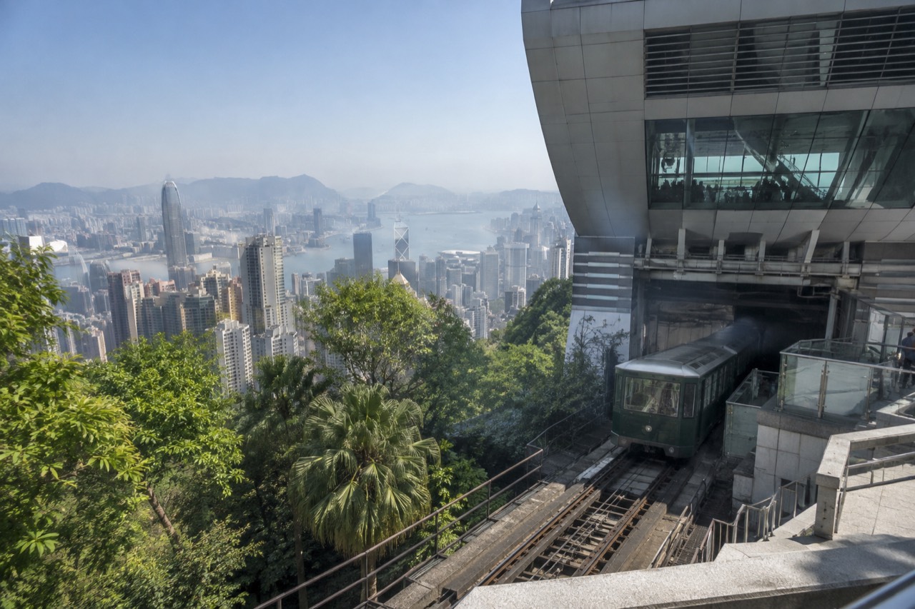The Peak Tram arriving at the upper terminus building on a hillside above Hong Kong harbour