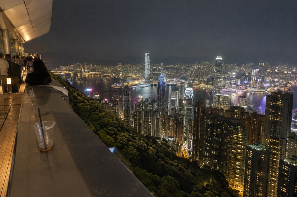 Rooftop viewing platform above the harbour at night with city lights spread below