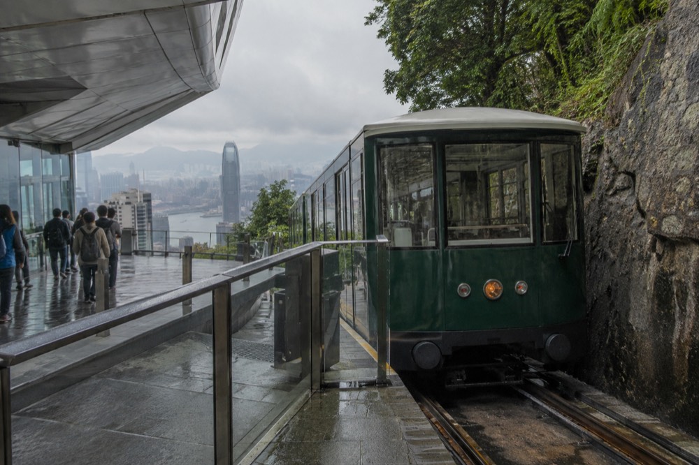 A green Peak Tram carriage at the upper terminus building on the hillside