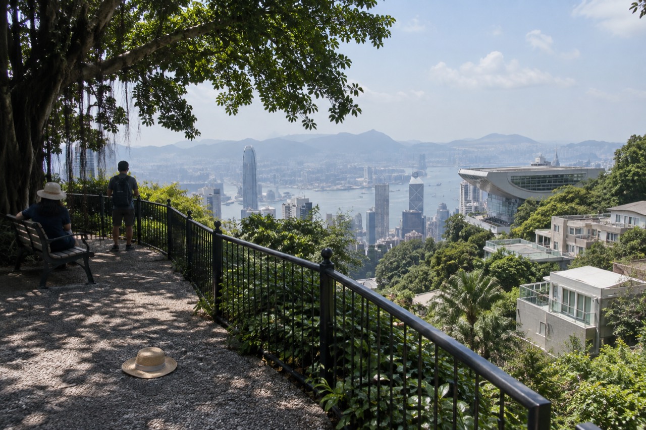 The Peak Tower and surrounding hillside buildings seen from a garden path above Hong Kong