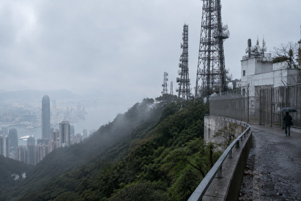 Wooded hillside rising above the rooftops and towers of central Hong Kong