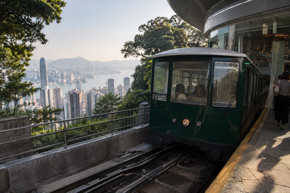 Peak Tram car arriving at the hillside terminus building above Hong Kong