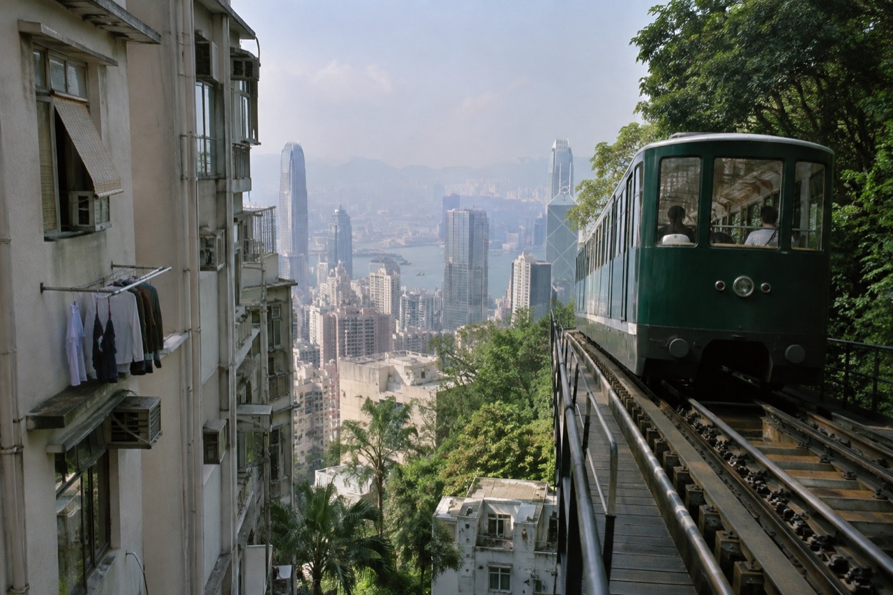 Peak Tram funicular car on its elevated track above Hong Kong apartment towers