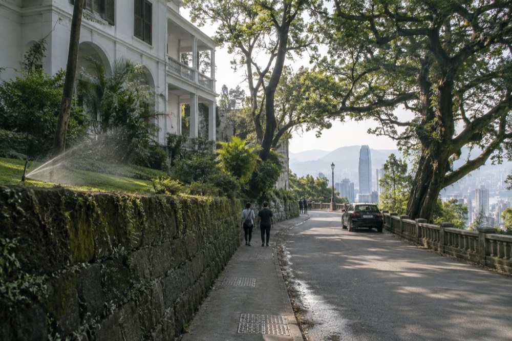 Historic colonial-era residences along a narrow tree-lined road on the Peak