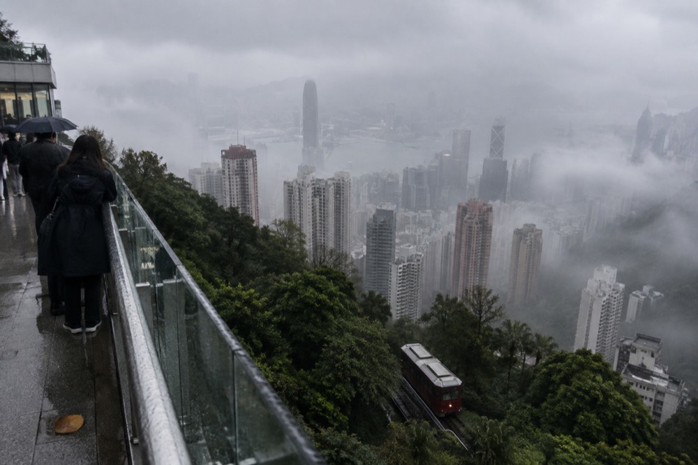 Thick sea fog rolling over Hong Kong Island hills and high-rise blocks
