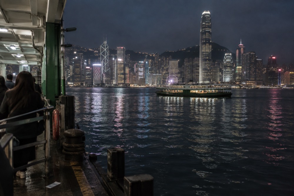Cool clear winter evening over Hong Kong harbour with city lights reflected on calm water
