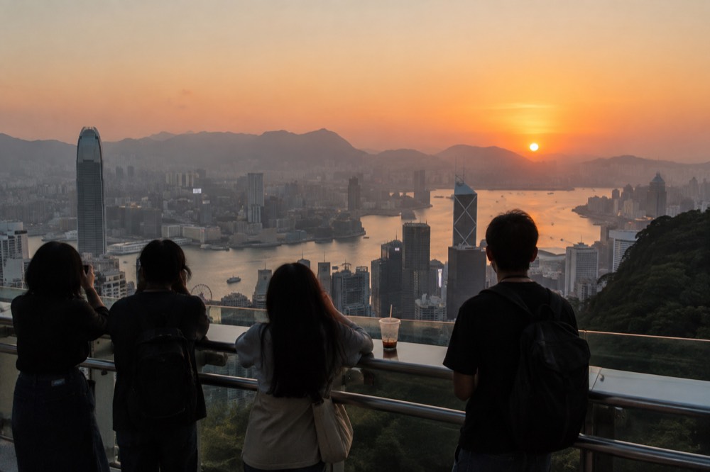Sunset light over Hong Kong skyline from a high outdoor observation deck with railings