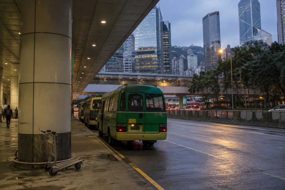 A green minibus parked at a transport interchange in central Hong Kong