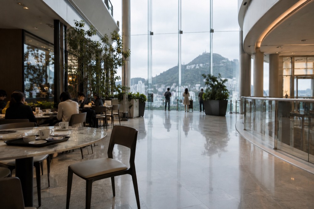 Modern mall interior atrium with shopfronts and a cafe seating area