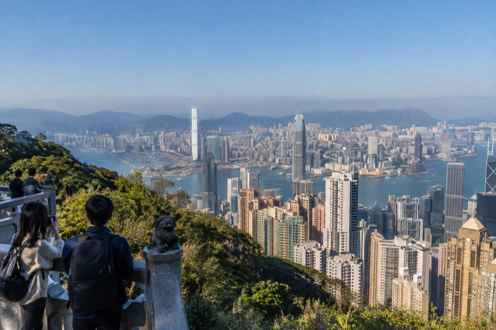 Hilltop viewpoint under a clear sky with the city and harbour stretching to the horizon