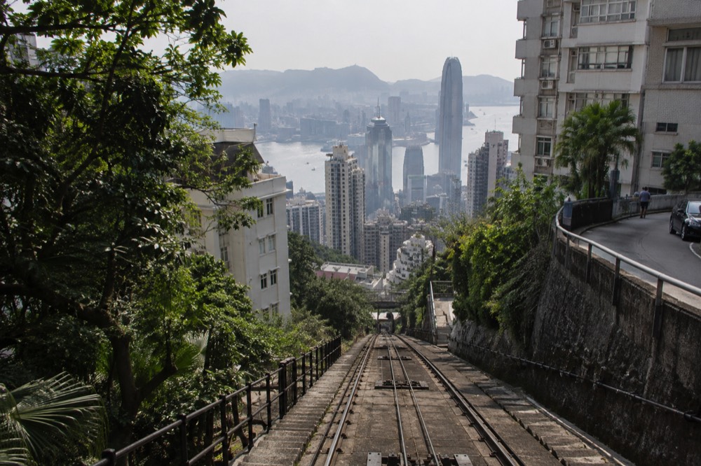 Steep funicular track rising past apartment buildings with the harbour in the background