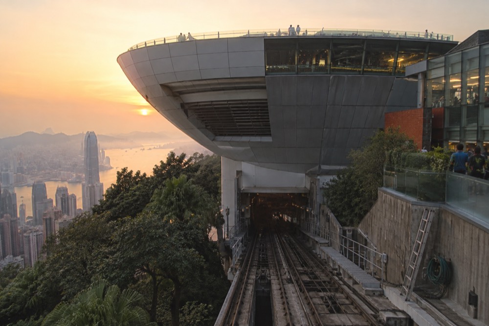 The wok-shaped Peak Tower building against the sky at the top of the funicular line