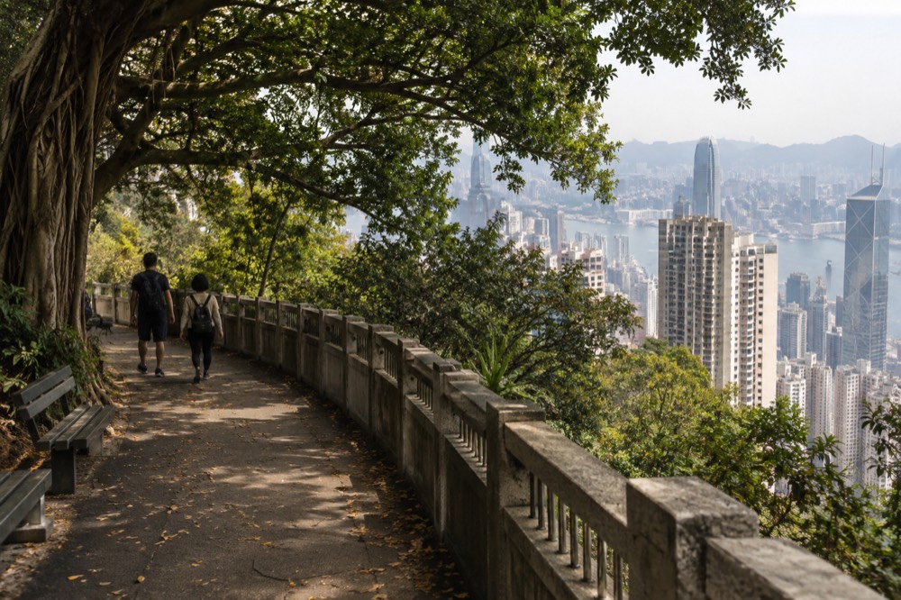 Flat tree-shaded walking path along Lugard Road curving around the Peak hillside