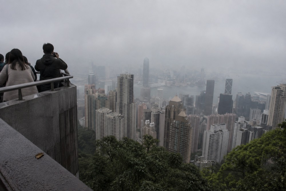 City towers rising into low cloud with a grey sky over the water