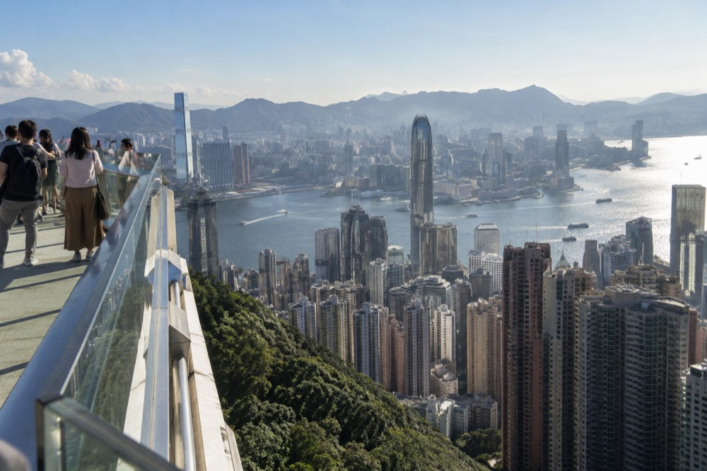 Skyscrapers of Hong Kong Island seen from above with ferries crossing the harbour