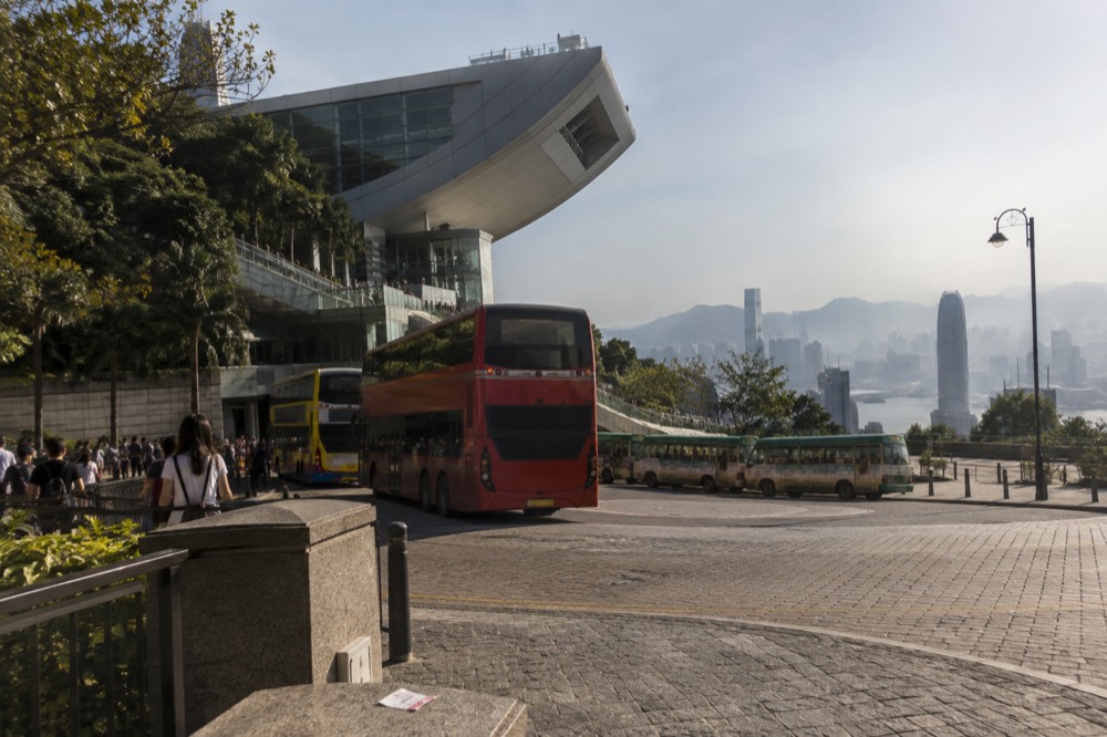 Bus and minibus terminus area at a hilltop with the city visible beyond