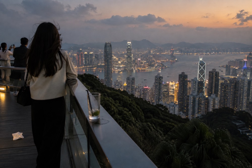 Observation deck railing overlooking the illuminated harbour and city towers at night