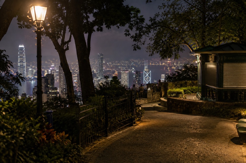 Gently lit garden path with city lights visible in the distance below