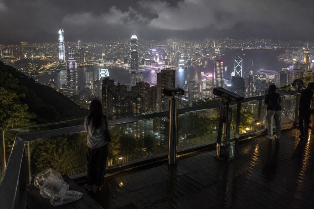 Harbour and city lights at night seen from a hillside railing