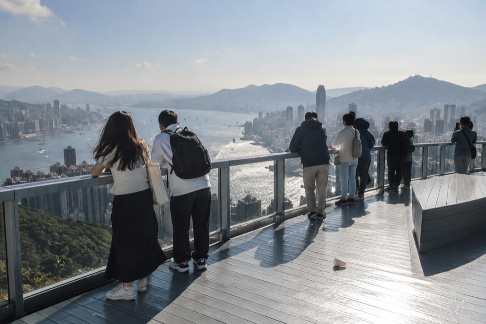 The open-air Sky Terrace 428 deck on the tower roof with visitors looking out over the harbour