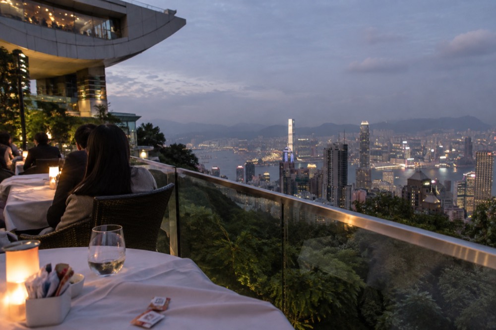 A restaurant terrace at The Peak Tower overlooking the city skyline in the evening