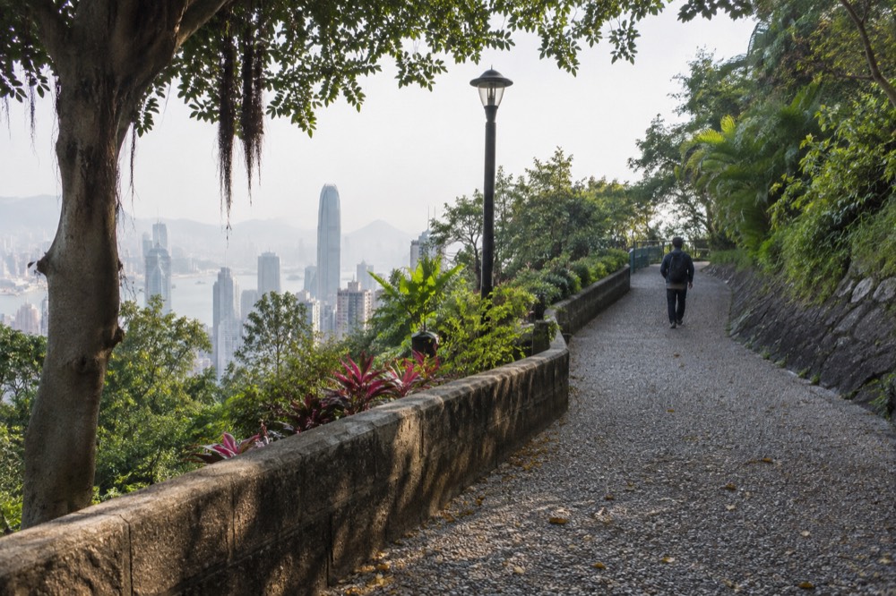 Park sign and path at the entrance to a green garden on a hillside