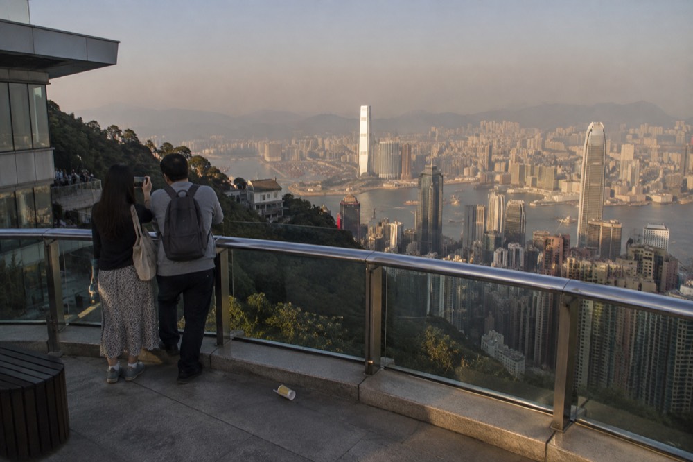 A free rooftop viewing deck overlooking Hong Kong skyscrapers and the harbour in late afternoon light