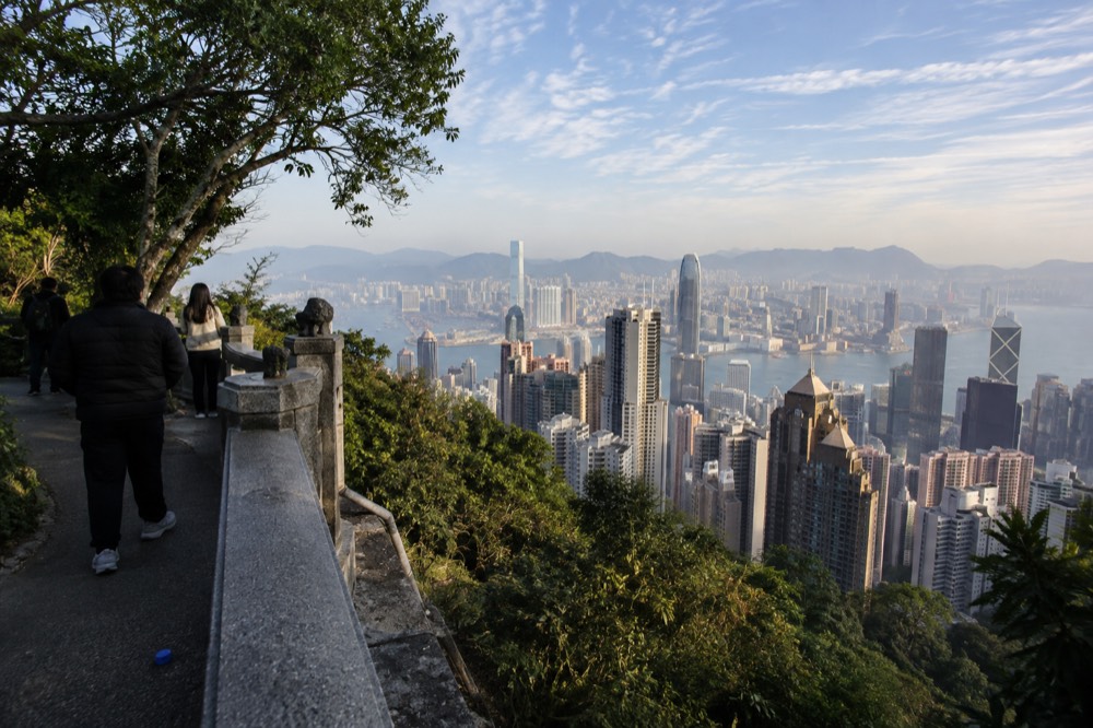 City skyline under a wide clear sky with thin cloud over the harbour