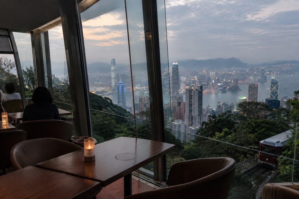 Restaurant interior with large windows overlooking a city skyline
